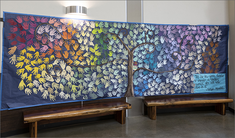 Mural of handprints with Nelson Mandela quote - It is in your hands to create a better world for all who live in it.